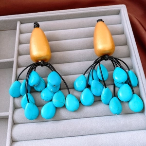 Detailed macro view of vintage ethnic drop earrings with golden metal and teal stone beads