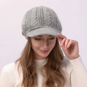 Detalle de gorra de punto trenzado gris que muestra la textura gruesa de lana