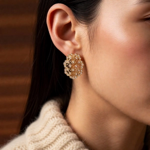 Detail of vintage French style hollow floral earrings with gold zircon on model