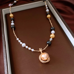 Détail du collier plaqué or avec pendentif perle dorée et perles de couleurs variées