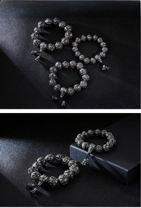 Detailed view of Buddhist prayer beads with mantra carvings and ritual tool charm
