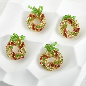 Detailed view of four beaded Christmas wreath pendants in red, green and gold crystals