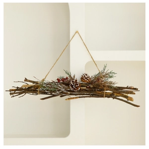 Close-up of Christmas wall hanging featuring pine cones, red berries, and frosted needles