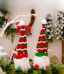 Détail de gnomes de Noël aux chapeaux rayés et clochettes sur des branches festives