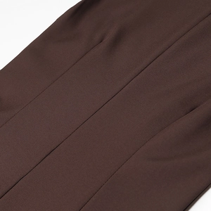 Detail of dark brown knit fabric with visible seams and fine texture on a slim maxi dress