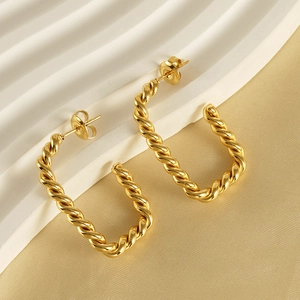 Boucles d'oreilles créoles torsadées en U dorées 18K sur fond de soie élégant
