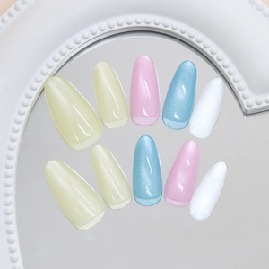 Pastel macaron cat eye press-on nails with glitter french tips on a mirror background