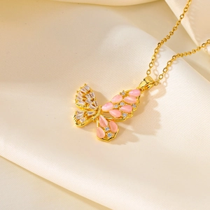 Elegant gold butterfly necklace with pink stone and zircons on beige satin background