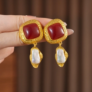 Detail of vintage square resin earrings with baroque pearls and gold hammered texture