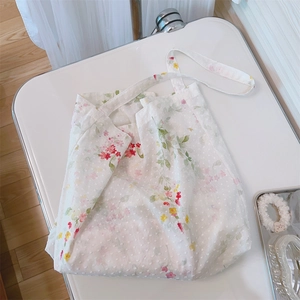 Close-up of white cotton tote bag featuring floral print and raised polka dot textures