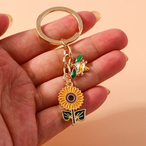 Golden keychain with enamel sunflower and bee charms on a circular metal ring