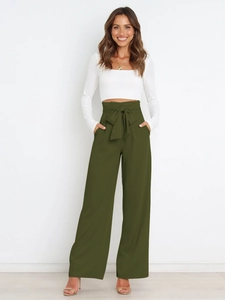 Detail of high-waisted olive green wide-leg trousers with decorative bow waist tie