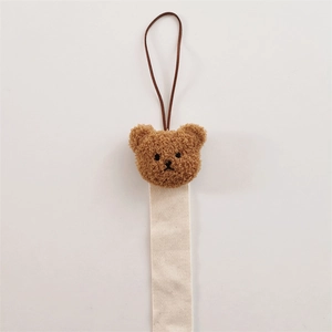 Detail of plush bear head organizer strap with cream herringbone ribbon pattern