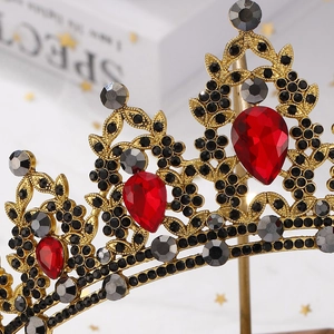 Close-up of vintage gold crown with red pear-cut gems and intricate filigree details