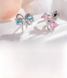 Detail of silver ribbon stud earrings featuring pink and blue pear-shaped zircons