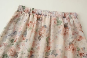 Détail de jupe mi-longue en mousseline à fleurs avec taille élastique et imprimé rose