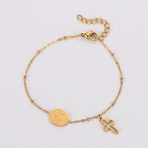 Detailed close-up of golden beaded chain bracelet with cross and religious figure charms
