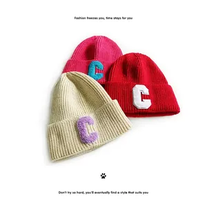 Knitted beanies in cream, red and pink featuring a plush 3D letter C patch detail