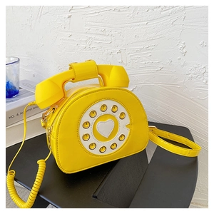 Detail of creative yellow patent leather handbag featuring a vintage telephone rotary design