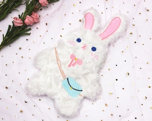 Détail de la trousse lapin en peluche blanche avec petit sac bleu et nœud rose