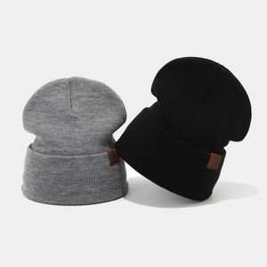 Winter knitted beanies in black and dark grey with leather patch for outdoor warmth