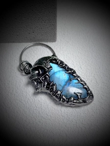 Macro shot of skull pendant featuring blue labradorite stone and vintage silver metal