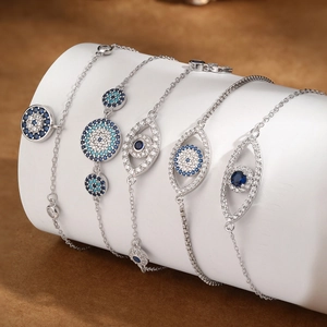 Detailed close-up of 925 silver evil eye bracelets with blue cubic zirconia on white display