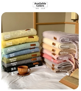Detail showing various macaron-colored cashmere-like scarves with a leather logo label