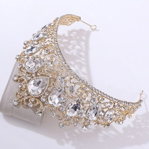 Detailed macro view of a gold Baroque crown featuring red crystals and sparkling rhinestones