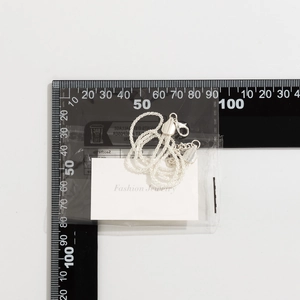 Detailed silver layered chain necklace measurement with cm scale on a white card background