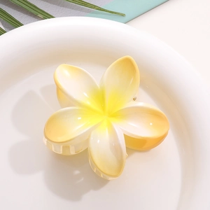 Macro detail of Frangipani shark hair claw clip in yellow and white gradient finish
