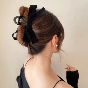 Elegant large black double bow hair claw clip styled on a low bun hair arrangement