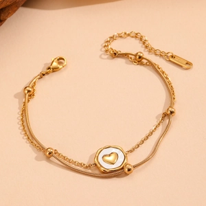Detail of 18k gold plated double layer bracelet with white shell heart pendant and beads