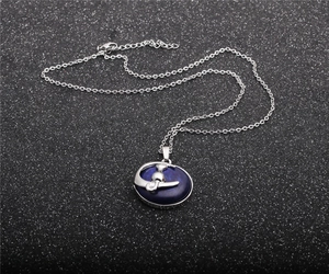 Macro detail of natural crystal moon cat pendant on a silver chain necklace
