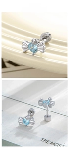 Dettaglio macro di orecchini a lobo argento a forma di caramella con zircone blu e chiusura a vite