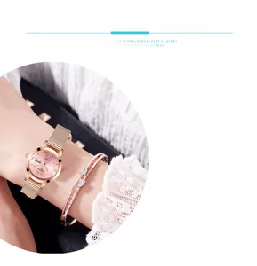Detail of rose gold quartz watch with mesh band and matching heart diamond bracelet