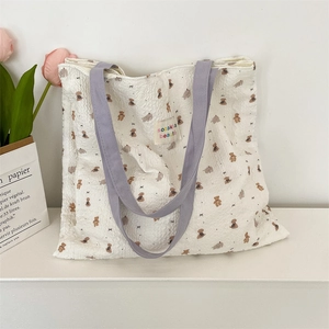 Detailed view of the embossed cartoon bear pattern on this stylish canvas shoulder bag