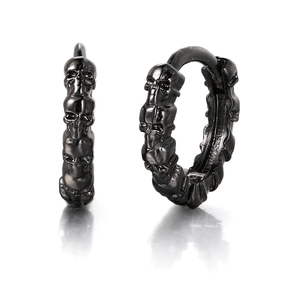 Macro shot of punk style black skull hoop earrings with detailed gothic metal carvings