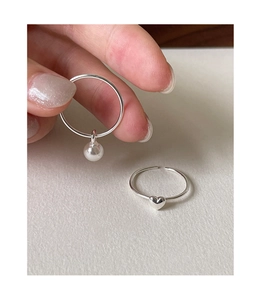 Macro shot of a 925 sterling silver heart ring and pearl pendant ring on white background