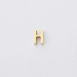 Macro view of a 1.8mm gold-plated stainless steel letter H bead for DIY jewelry making
