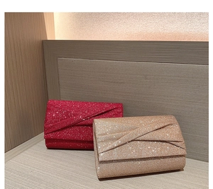 Détails des pochettes de soirée pailletées rouges et dorées au design enveloppe