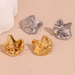 Detailed view of 18K gold and silver plated earrings with irregular hammered texture
