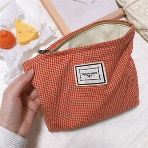 Detail of red houndstooth cotton makeup bag with silver zipper and Time to Party patch