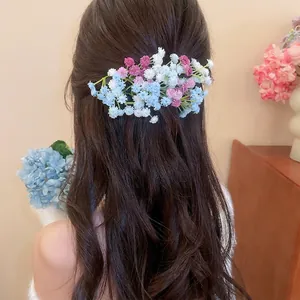 Elegant light blue and purple acrylic flower cluster hair clip on long wavy hair