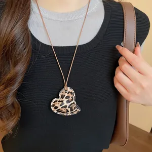 Retro heart leopard print pendant necklace with brown leather cord on female model