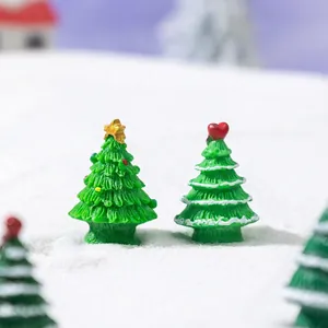 Miniature Christmas trees with star and heart toppers on snowy landscape scene