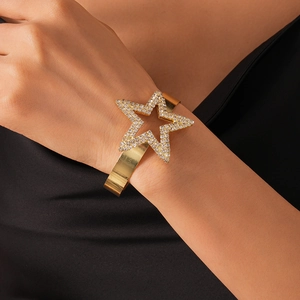 Close-up of gold star cuff bracelet with sparkling rhinestones worn on a model's arm