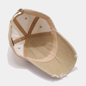 Détail de la casquette beige avec effet usé et étiquette de lavage intérieure