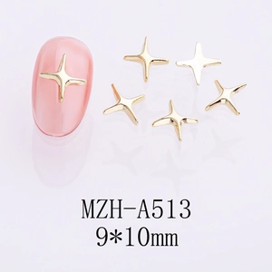 Détail des breloques à ongles en forme d'étoile dorée sur des ongles roses