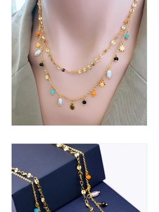 Detailed close-up of double-layer gold star necklace with pearls and colored beads